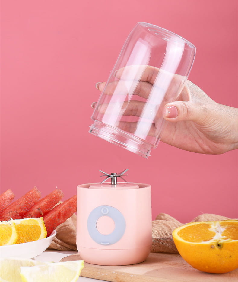 pink cylindrical glass usb automatic mini portable blender with light blue circular button and metallic blade assembly for juicing