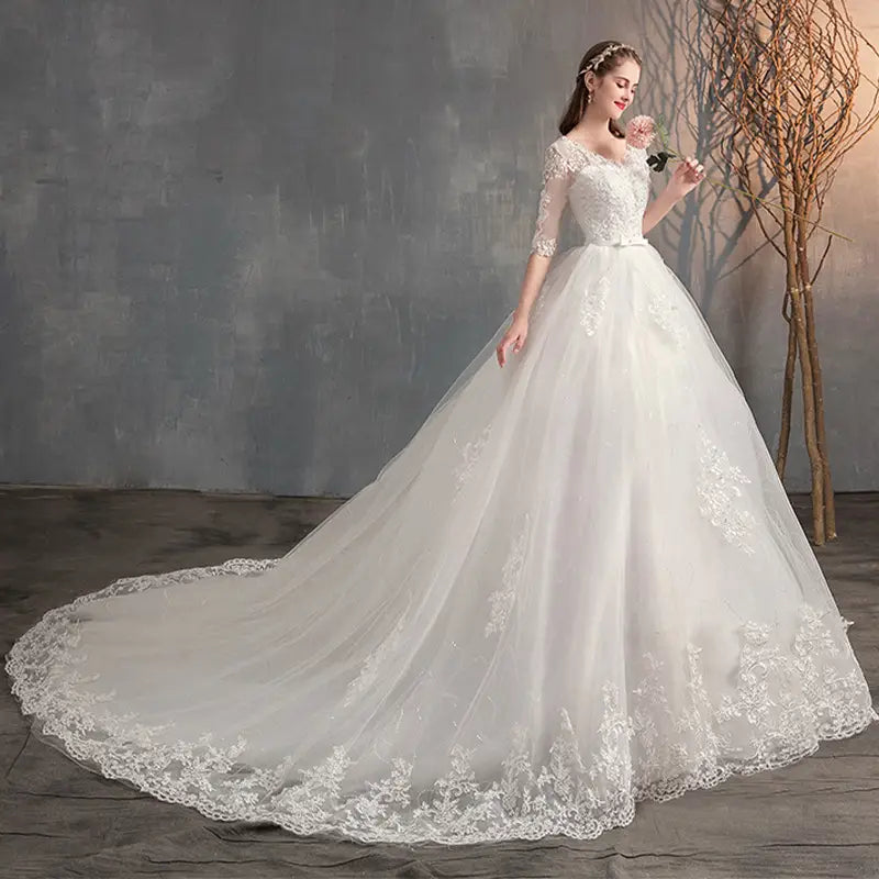 Elegant white high waist wedding dress trailing with intricate lace detailing and a flowing tulle skirt
