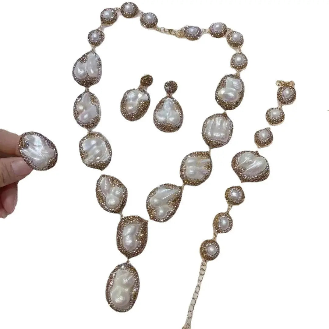 A luxurious baroque pearl necklace ring suit featuring irregular white pearls encased in gold-toned metalwork with diamond accents designed for the ring suit bride.