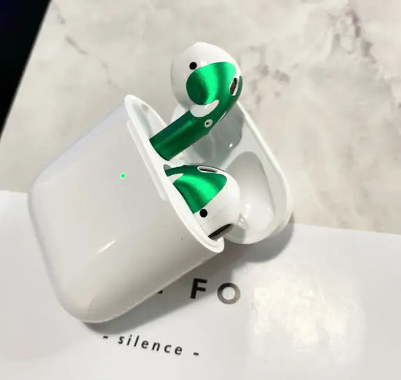 green and white wireless apple airpods with a custom sticker skin in a matching charging case showcasing a gold glossy custom sticker skin design