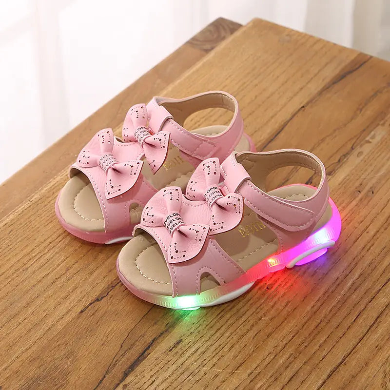 pink children’s sandals with decorative bows and white led flashing along the sole for cute flower flashing princess use