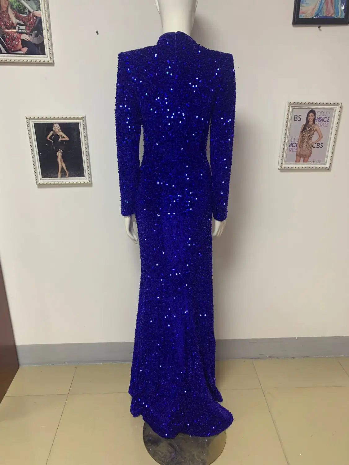 a dazzling royal blue siren ji sequin floor-length gown with long sleeves, a high collar, and a high slit displayed on a mannequin