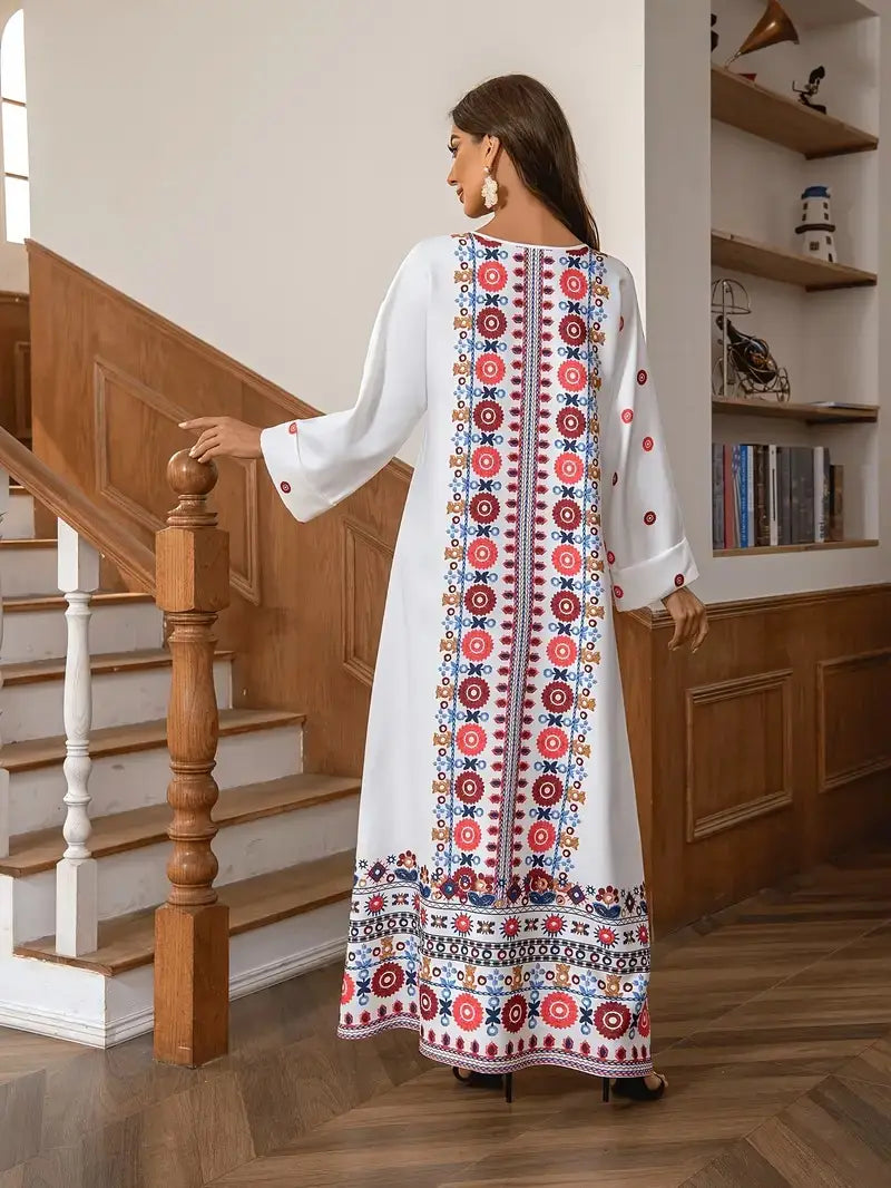 White embroidered rhinestone bead long sleeve maxi dress with a vibrant floral print of red, blue, and gold circular motifs along the back and hem, shown from the back side.