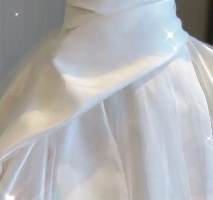 a flowing white tulle skirt with soft layered texture and delicate pleats in a temperament princess style french satin gown