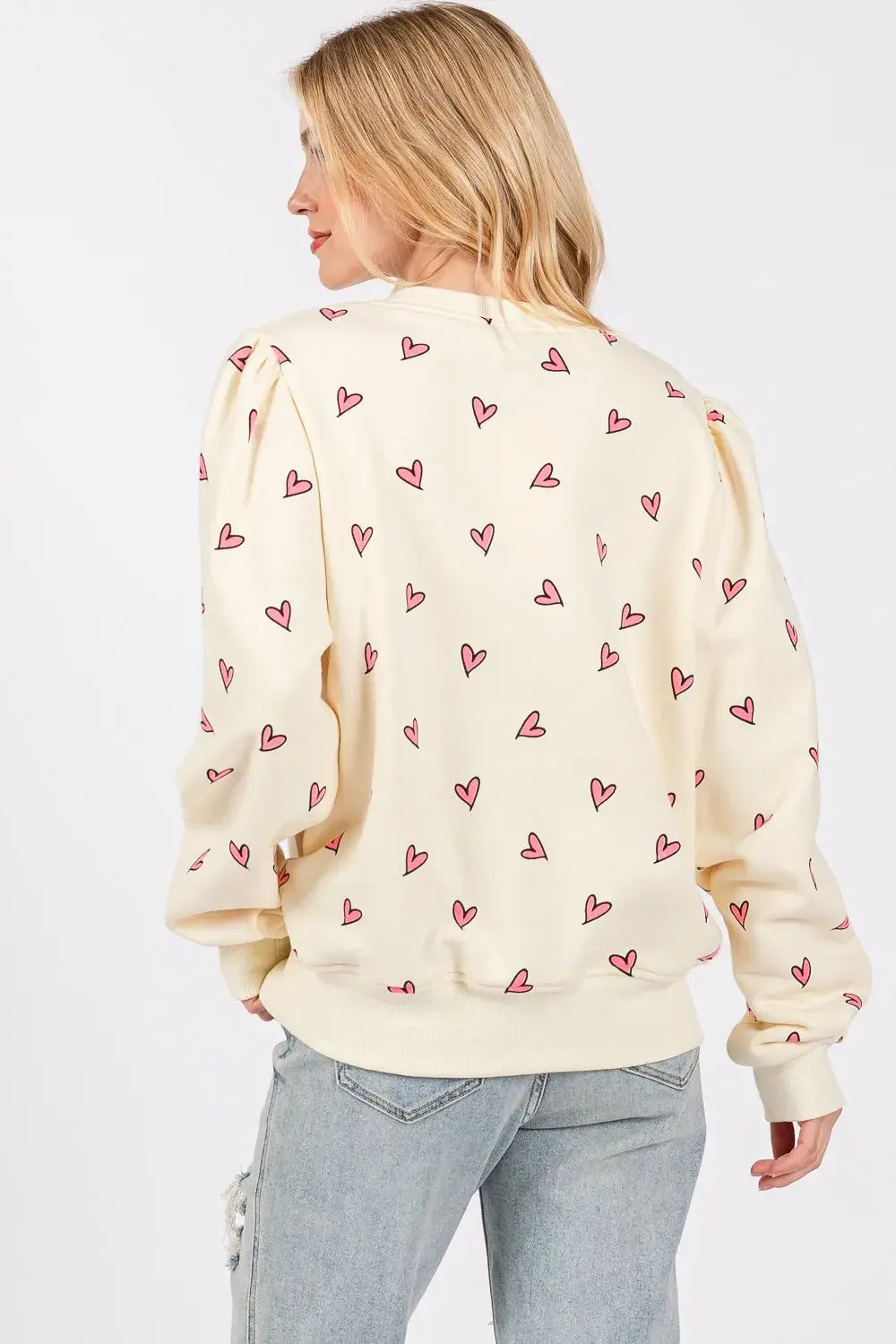 Cream-colored sage fig heart printed long sleeve sweatshirt featuring a playful pattern of small pink hearts scattered across the fabric.