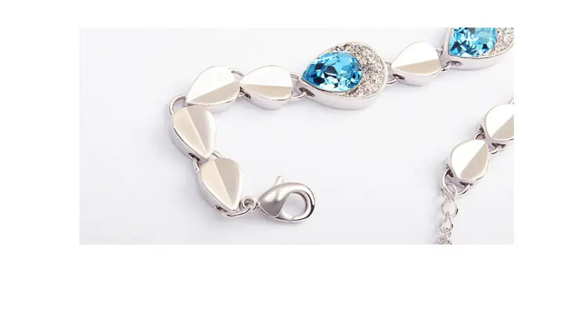 Silver-toned creative alloy jewelry bracelet featuring teardrop-shaped blue crystals and pave-set clear stones with sleek leaf-inspired links from the blue crystal alloy jewelry set necklace.