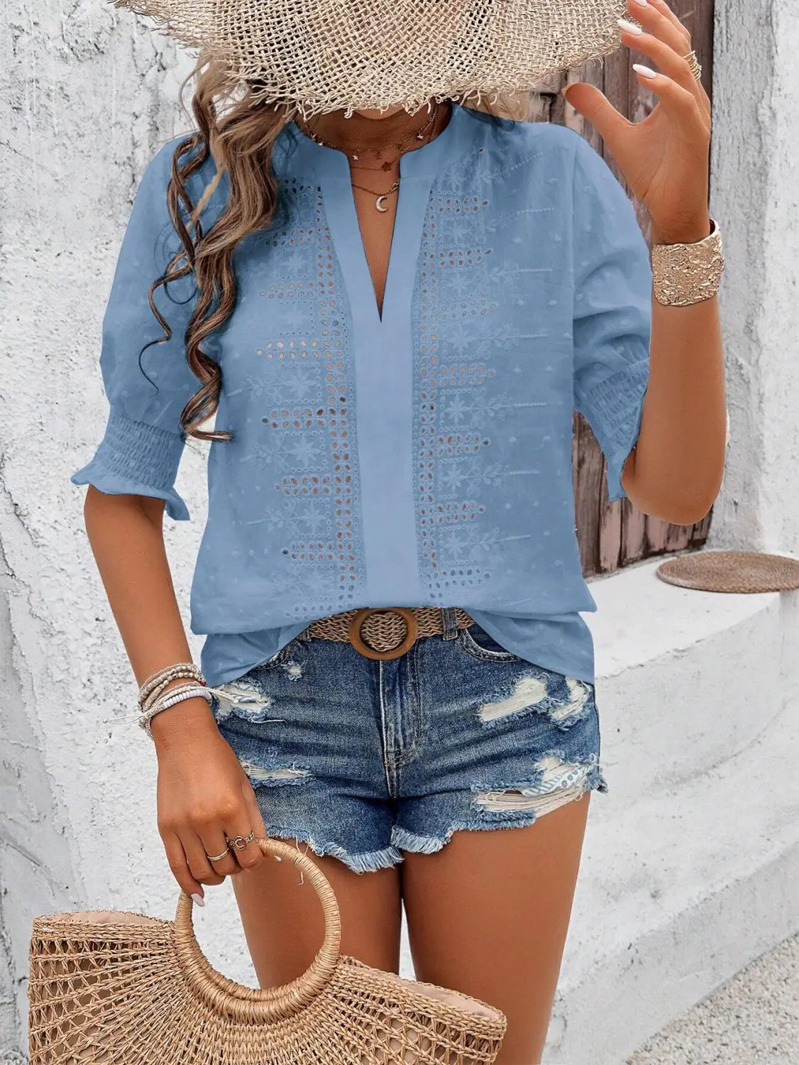 Light blue embroidered blouse with v-neck and three-quarter sleeves featuring white eyelet puff sleeve and hollow hair ball details.