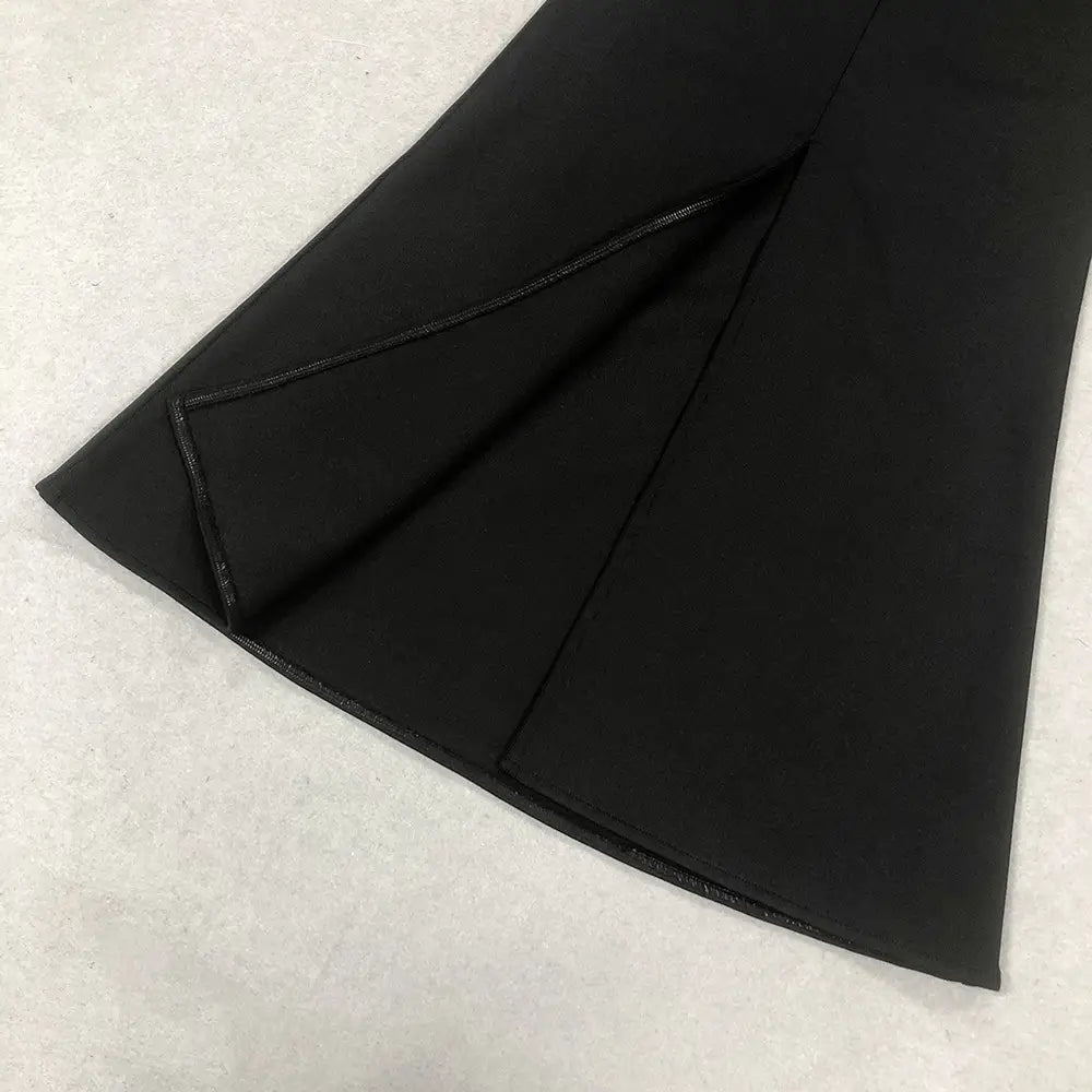 black fabric skirt with smooth sleek texture and precise stitching along the hem of a black satin bandage golden flower maxi dress