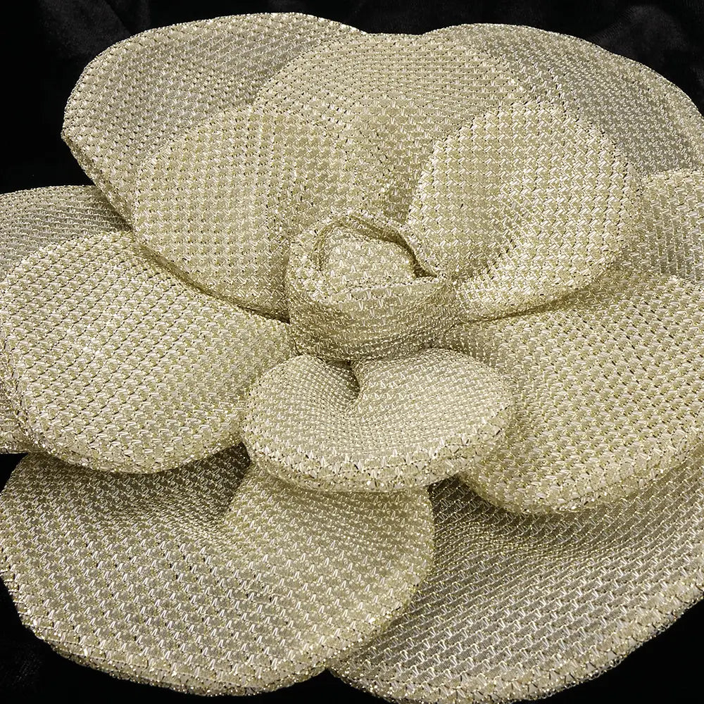 a shimmering gold metallic mesh flower brooch on a black camisole backless slim fit velvet floral gown
