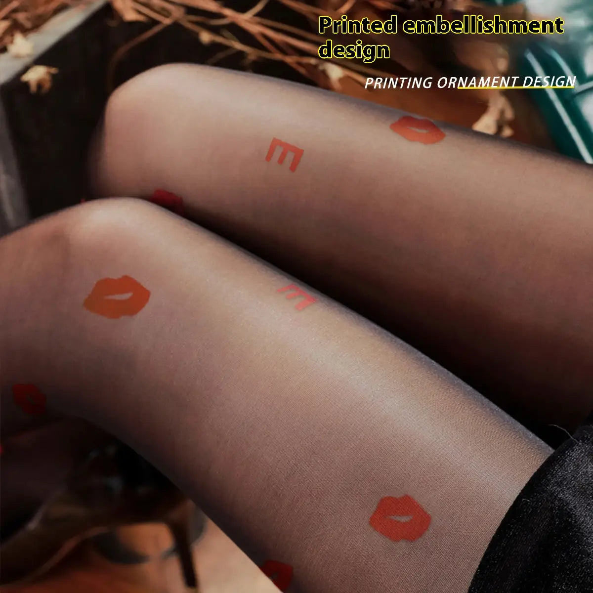 black transparent sheer snagging resistant sock leggings featuring playful orange lipstick prints and red letter e patterns