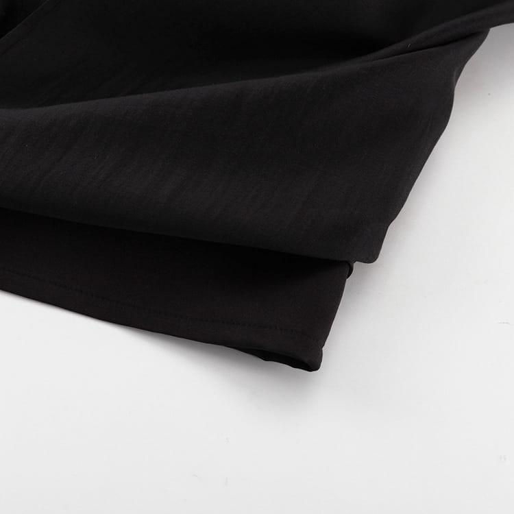 black soft-textured fabric folded neatly on a white surface for a high waist slit sheath skirt