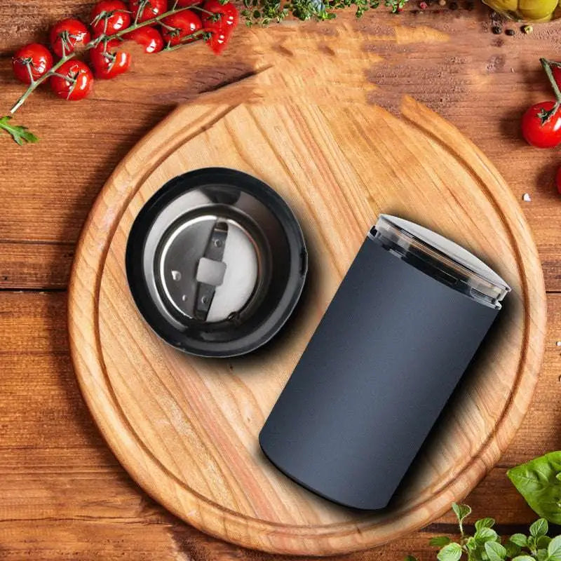 Black matte-finish electric herb grinder with transparent base designed and removable chamber for grinding herbal coffee
