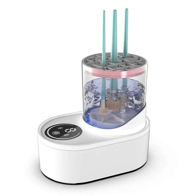 White electric makeup brush cleaner with transparent cylindrical tank and pink rim holding teal-handled brushes submerged
