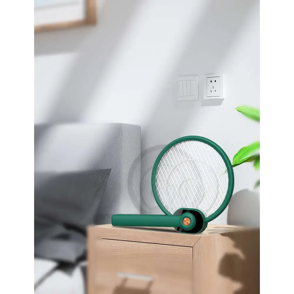 Green electric mosquito swatter with circular mesh head and ergonomic handle featuring mosquito trap mode for effective insect control