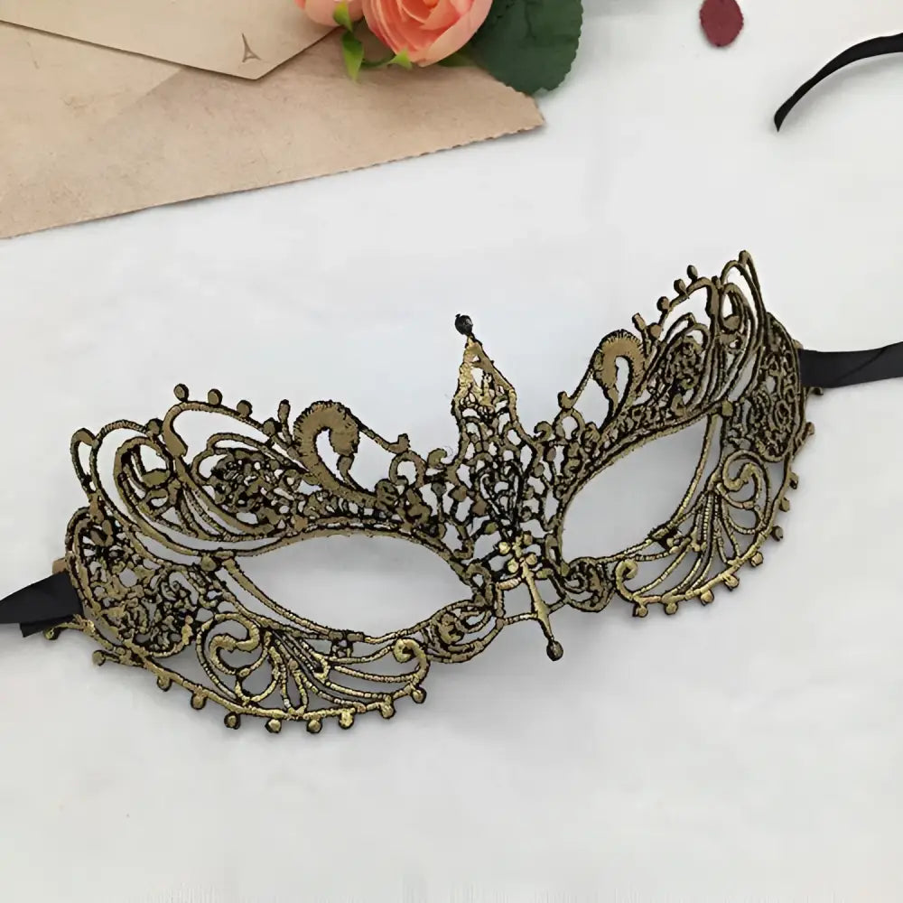 Elegant gold lace mask with intricate filigree design and black elastic straps for pointed Halloween events