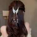 Silver angel-wing hair clip with dangling pearl drops resembling an elegant golden pearl tassel hairpin design