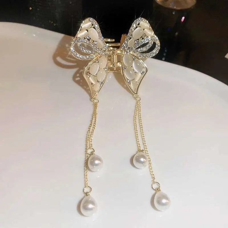 Elegant golden pearl tassel hairpin featuring a gold-toned bow with sparkling rhinestones and dangling pearl drops