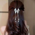 Elegant silver bow hair clip featuring dangling pearl drops resembling a golden pearl tassel hairpin design