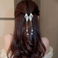 Elegant golden pearl tassel hairpin with a delicate white lace bow and dangling pearl drops for hair decoration