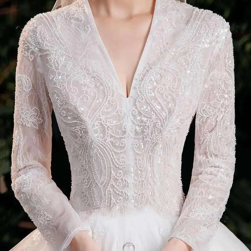 Elegant lace bridal white ball gown with intricate lace detailing and trailing long sleeves for a bridal temperament look