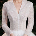 Elegant lace bridal gown in white featuring long sleeves and intricate lace detailing with bridal temperament trailing design