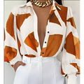 Elegant loose geometric print lantern sleeve blouse in white and orange with long sleeves deep v-neckline and black buttons