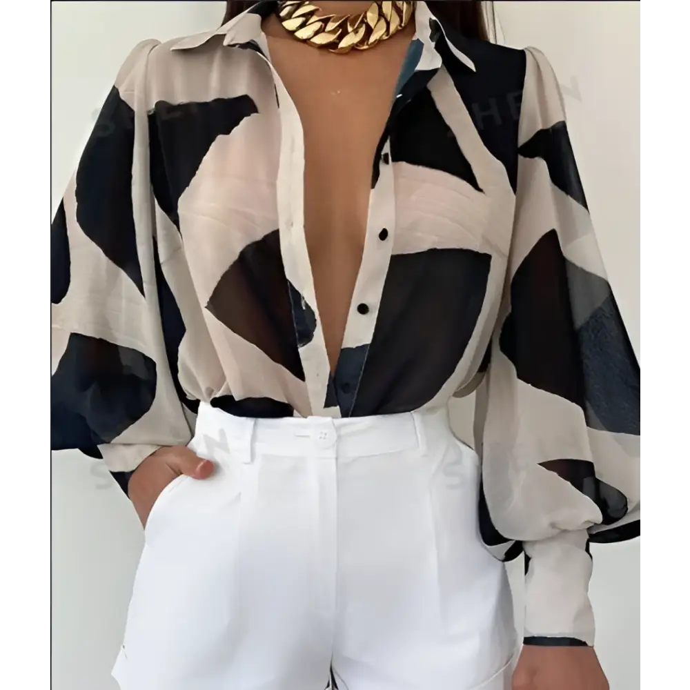 Elegant loose geometric print lantern sleeve blouse in white and orange with long sleeves deep v-neckline and black buttons