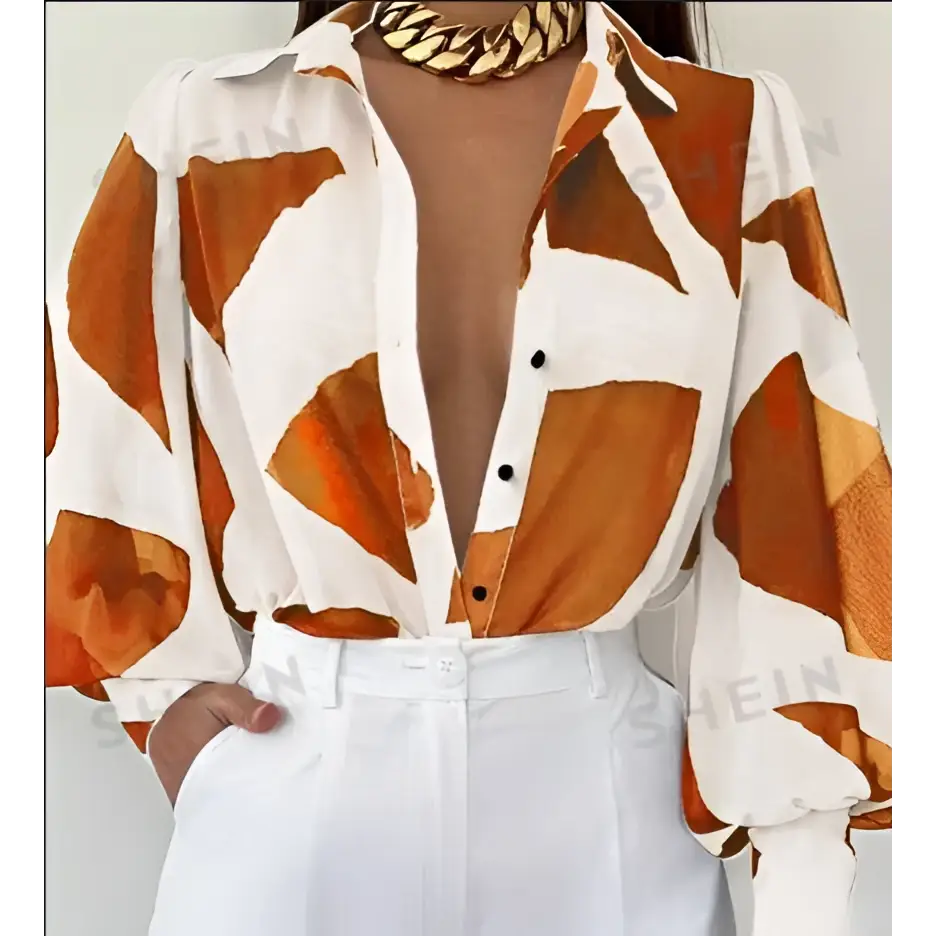 Elegant loose geometric print lantern sleeve blouse in white and orange with long sleeves deep v-neckline and black buttons