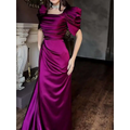 A shimmering magenta satin magenta maxi dress featuring an elegant puff sleeve and ruched bodice with pleated slit