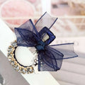 Elegant rhinestone mesh navy blue sheer bow hairpin with gold-toned band and white floral accents hairpin fashion lace