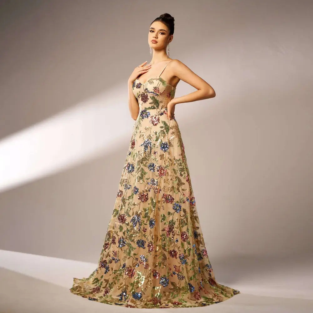 Elegant sleeveless sequined suspender evening dress in champagne with intricate blue green and burgundy floral embroidery