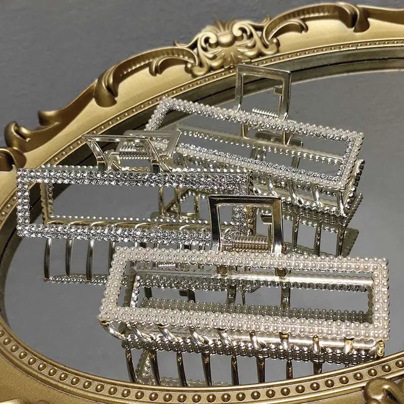 Elegant sweet pearl silver claw clip with a silver rectangular frame adorned with sparkling rhinestones along edges