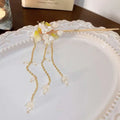 Elegant white floral temperament hairpin with gold tone, delicate flowers, and dangling pearl-like charms on chains