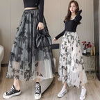 Two women model mid-length embroidered bow lace mesh skirts with black butterfly embroidery on gray and white mesh