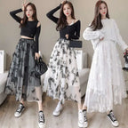Three women model mid-length embroidered bow lace mesh skirts in sheer gray and white with black butterfly embroidery