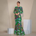 A vibrant emerald green evening gown featuring embroidered floral long sleeves with intricate pink blue and gold embroidery