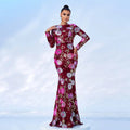 A shimmering burgundy evening gown with embroidered floral patterns in pink silver and gold sequins and long sleeves