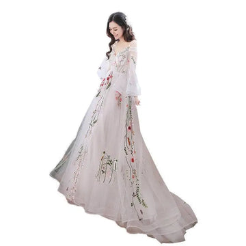A flowing off-the-shoulder retro bridal gown in sheer pale gray tulle featuring delicate floral embroidery with red and green accents