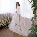 A flowing white tulle off-the-shoulder retro bridal gown with delicate red pink and green floral embroidery