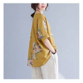 A loose-fitting mustard-yellow embroidered Korean cotton hemp top with floral embroidery in pastel pinks and blues