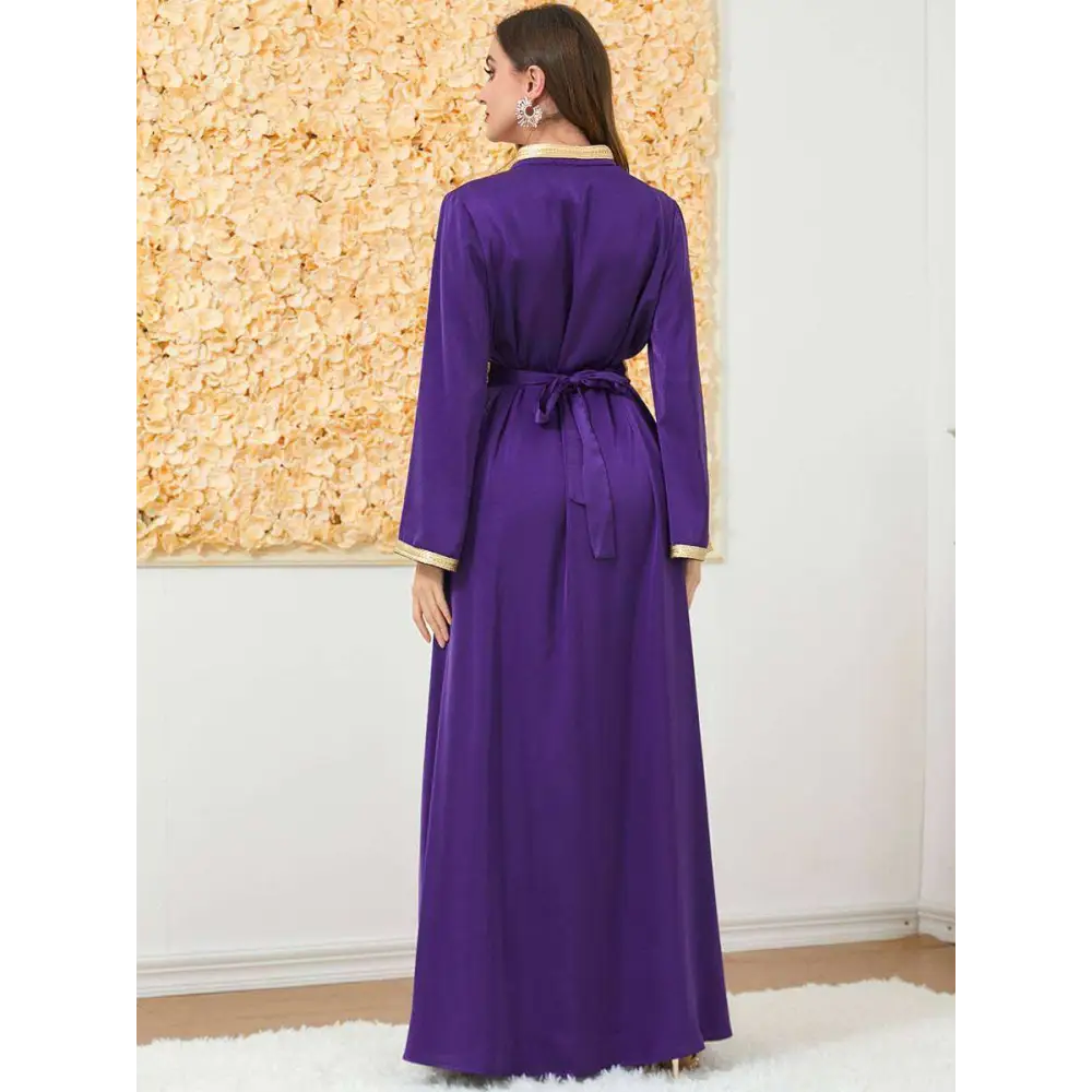 A flowing purple satin embroidered long sleeve foreign trade dress robe with gold thread detailing on cuffs and collar tied at waist