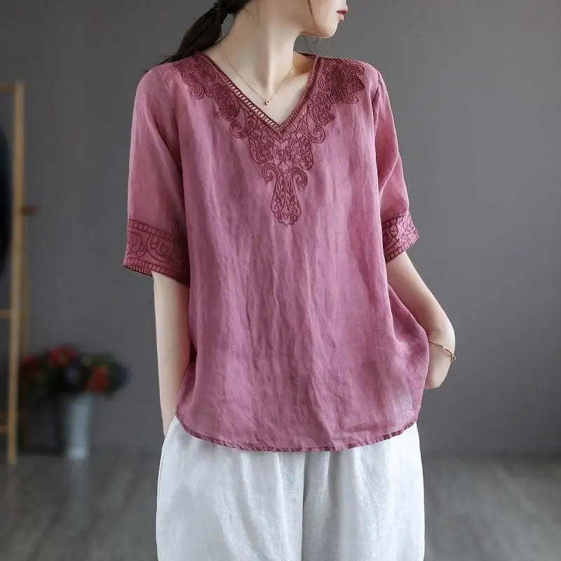 A soft pink cotton linen blouse with intricate dark red embroidery on the v-neckline and sleeve cuffs fashion retro cotton