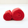 Two neatly rolled red stepping pants made of nylon single layer paired with an embroidered red cardigan product display