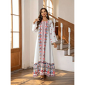 A flowing white embroidered rhinestone bead sleeve maxi dress with intricate red blue and pink floral print patterns