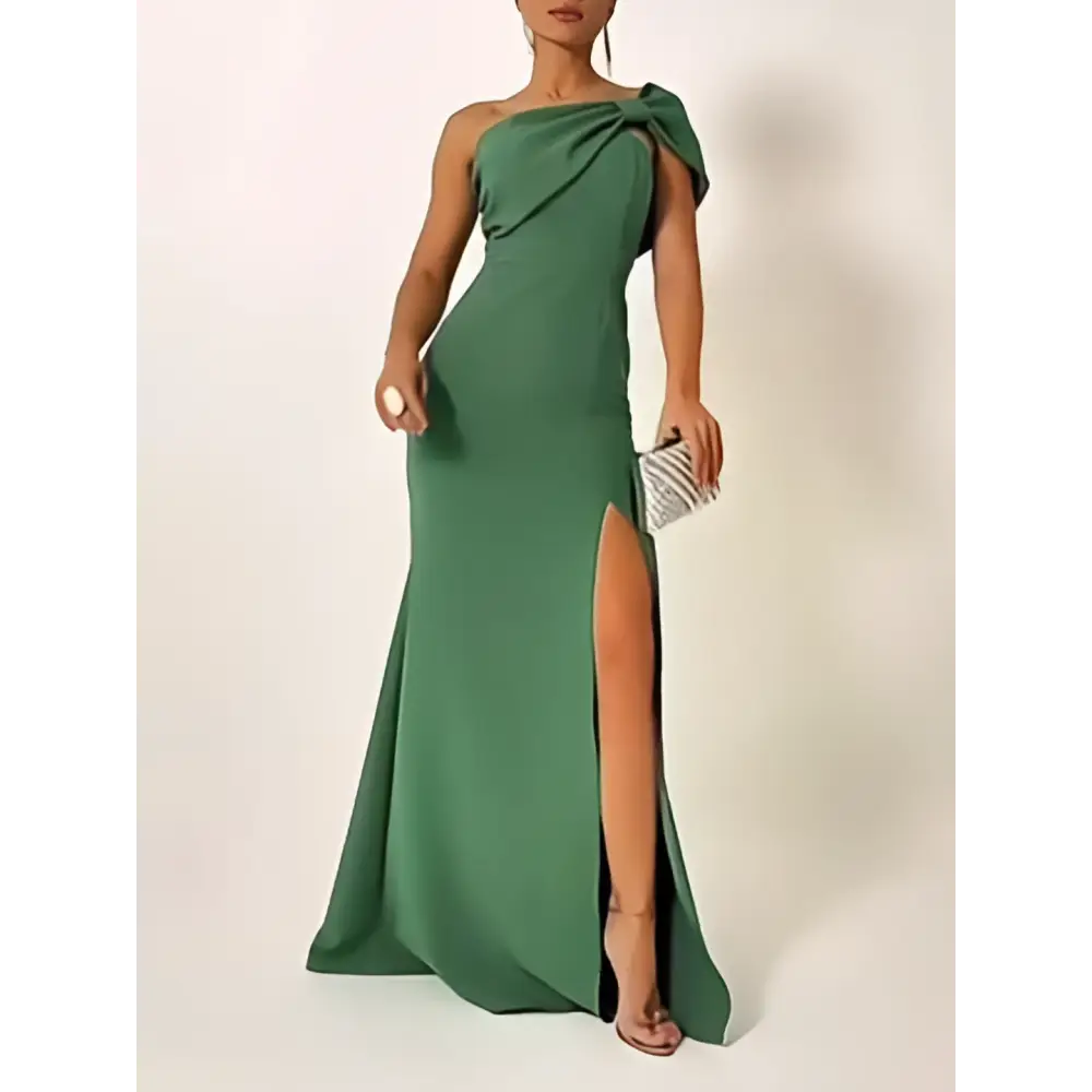 A sleek emerald green bow shoulder evening gown with one shoulder high slit and draped fabric detail