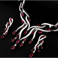 A sparkling silver zircon jewelry set featuring a necklace and earrings with vibrant red gemstones in an elegant design