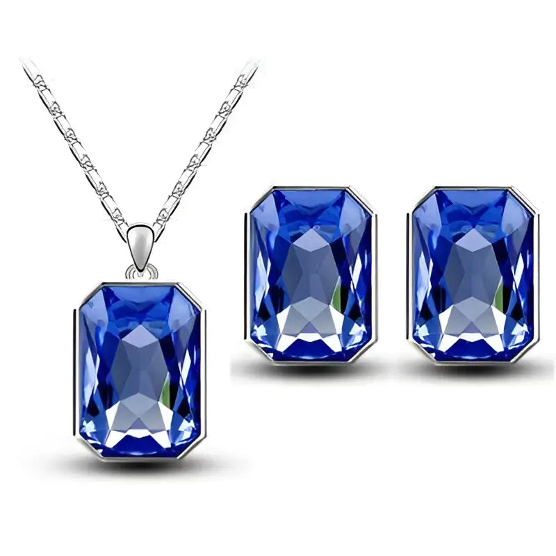 A pair of royal blue rectangular-cut gemstone earrings and matching silver pendant necklace in an emerald green crystal set