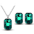 Emerald green crystal necklace pendant and matching earrings set in silver-toned metal for elegant wear