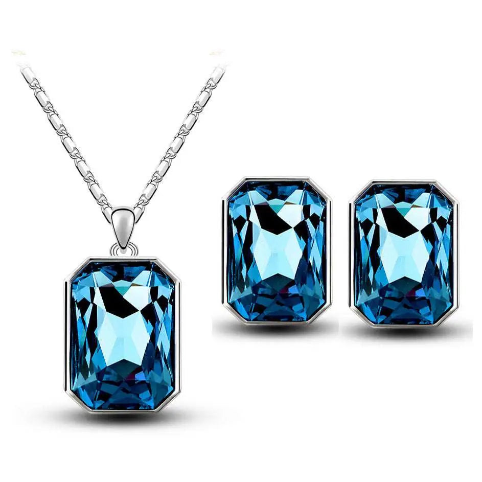 Elegant silver-toned emerald green crystal necklace and earring set with rectangular pendant and octagonal cut stones