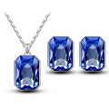 A pair of elegant blue rectangular emerald green crystal earrings and matching silver crystal necklace pendant set